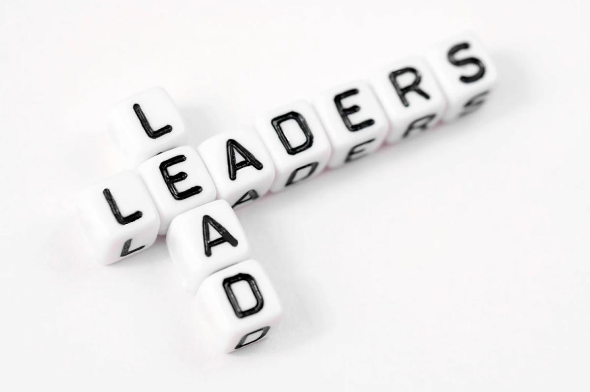 White lettered cubes spelling "LEADERS" horizontally and "LAD" vertically on a white background.